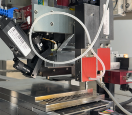 Detail of a dispensing head for placing small parts and dispensing UV adhesive.
